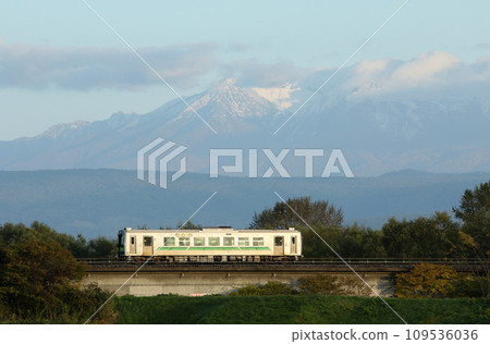Soya Main Line local train running with snow-capped Mt. Daisetsu in the background JR Hokkaido H100 DECMO Soya Main Line local train running with snow-capped Mt. Daisetsu in the background JR Hokkaido H100 DECMO 109536036