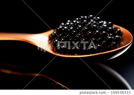 Closeup of natural black caviar on a golden spoon on black background, texture of fresh sturgeon caviar macro photo. Closeup of natural black caviar on a golden spoon on black background, texture of fresh sturgeon caviar macro photo. 109536331