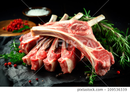 Raw fresh rack of lamb with green herbs on black background Raw fresh rack of lamb with green herbs on black background 109536339