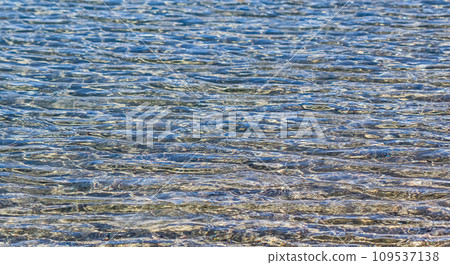 Blue sea in sunshine glow as surface background. Summer holidays concept Blue sea in sunshine glow as surface background. Summer holidays concept 109537138