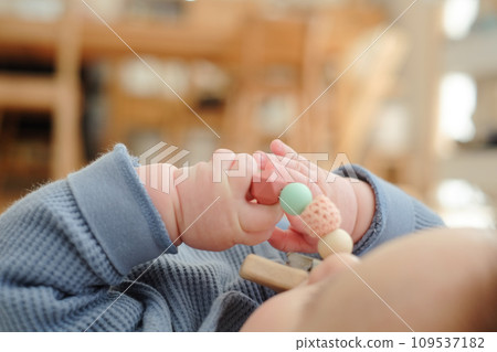 嬰兒手將矽膠珠牙膠含在嘴裡的特寫 嬰兒手將矽膠珠牙膠含在嘴裡的特寫 109537182