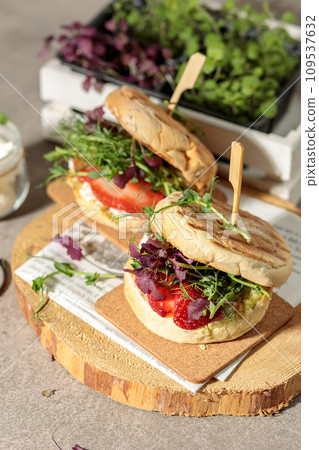 Lean burgers with a corn flour bun, micro greenery and slices of fresh berries. Close-up, natural light 109537632