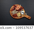 Snack board with dried and salted fish and squid. Top view on black background, copy space. fish plate 109537637