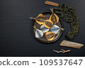 a plate of dried fish on a black background. Top view on a black background with an eco shopper. 109537647