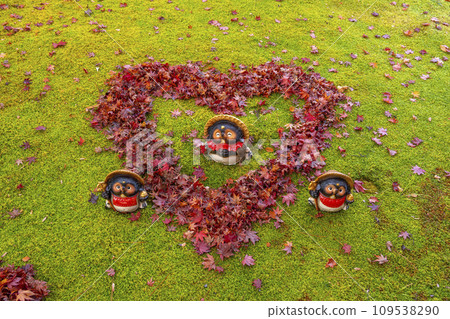 Kyoto in autumn, Adashino Nenbutsuji Temple, heart-shaped fallen leaves and raccoon statue 109538290