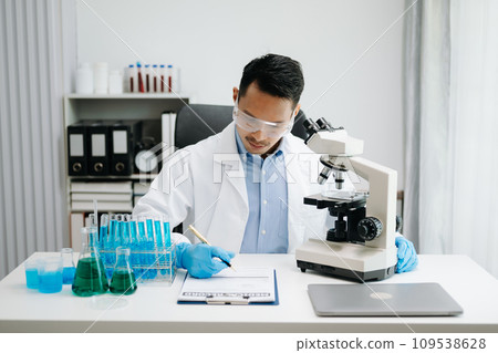 Modern medical research laboratory. male scientist working with micro pipettes analyzing biochemical samples, advanced science chemical laboratory medicine. Modern medical research laboratory. male scientist working with micro pipettes analyzing biochemical samples, advanced science chemical laboratory medicine. 109538628