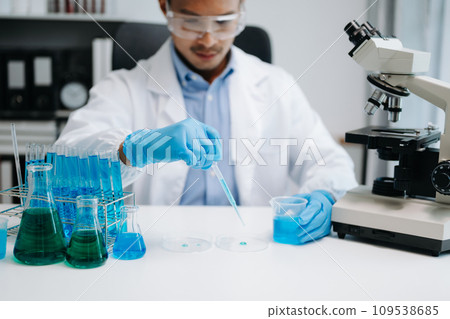 Scientist mixing chemical liquids in the chemistry lab. Researcher working in chemical laboratory. Scientist mixing chemical liquids in the chemistry lab. Researcher working in chemical laboratory. 109538685