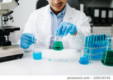 Scientist mixing chemical liquids in the chemistry lab. Researcher working in chemical laboratory. Scientist mixing chemical liquids in the chemistry lab. Researcher working in chemical laboratory. 109538740