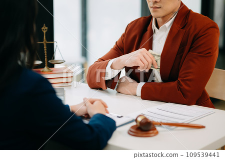 justice and law concept.passing bribe money in the envelop at lawyer office. businessman hand taking bribe money from female 109539441