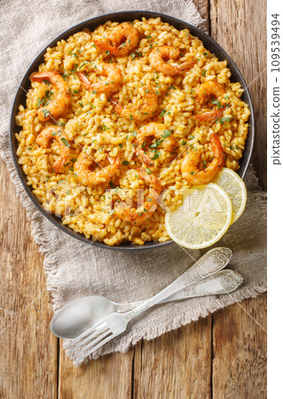 Healthy seafood dish Risotto with shrimp, lemon and fresh herbs closeup on the plate. Vertical top view Healthy seafood dish Risotto with shrimp, lemon and fresh herbs closeup on the plate. Vertical top view 109539494