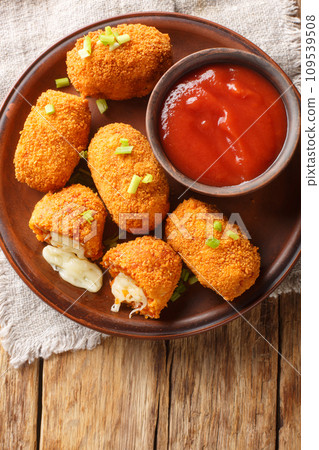 Suppli al telefono from Rome consists of deep-fried risotto rice with bolognese sauce and melting mozzarella closeup on the plate. Vertical top view 109539508