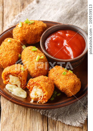 Suppli al telefono italian fast food fried tomato rice croquettes stuffed with mozzarella closeup on the plate. Vertical Suppli al telefono italian fast food fried tomato rice croquettes stuffed with mozzarella closeup on the plate. Vertical 109539513