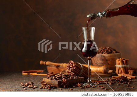 Coffee liquor is poured from a bottle into a glass. Coffee liquor is poured from a bottle into a glass. 109539993