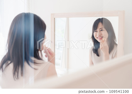 young woman doing makeup at home 109541100