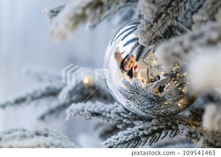 smiling women reflection in christmas tree toy 109541465