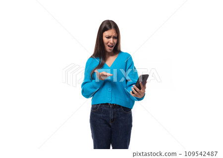 charming caucasian woman with black hair dressed in a blue cardigan watches attentively the video on charming caucasian woman with black hair dressed in a blue cardigan watches attentively the video on 109542487