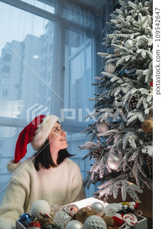 happy smiling woman decorating christmas tree 109542647