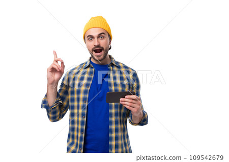 young stylish brunette man with a brutal beard and mustache dressed in a hat and shirt is inspired 109542679