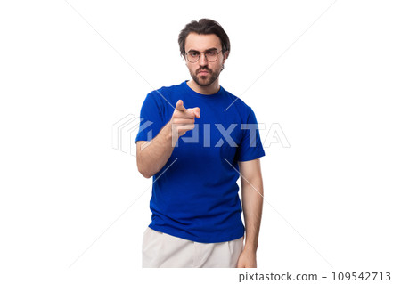 A 30 year old surprised European guy with black hair and a beard in a blue T-shirt points to the 109542713