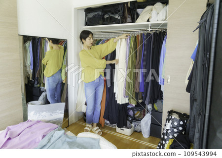 Young woman choosing clothes from closet in the morning 109543994