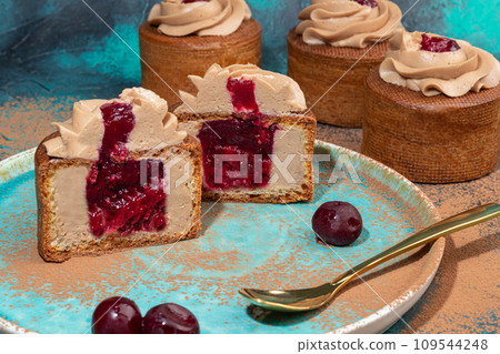 Cakes filled with cream and cherry jam. Box eclairs. New Year and holiday concept. 109544248