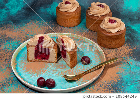 Cakes filled with cream and cherry jam. Box eclairs. New Year and holiday concept. 109544249