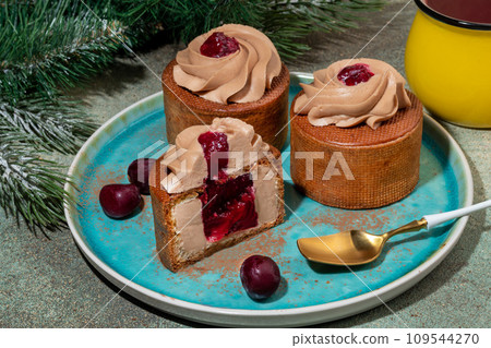 Cakes filled with cream and cherry jam. Box eclairs. New Year and holiday concept. Cakes filled with cream and cherry jam. Box eclairs. New Year and holiday concept. 109544270