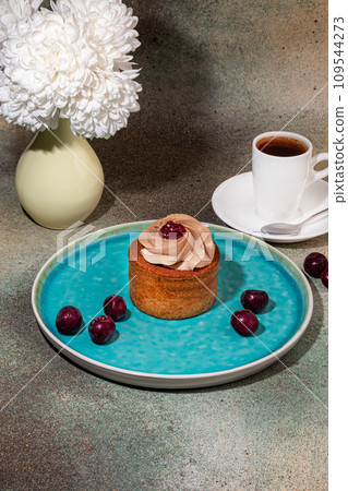 Cakes filled with cream and cherry jam. Box eclairs. New Year and holiday concept. 109544273