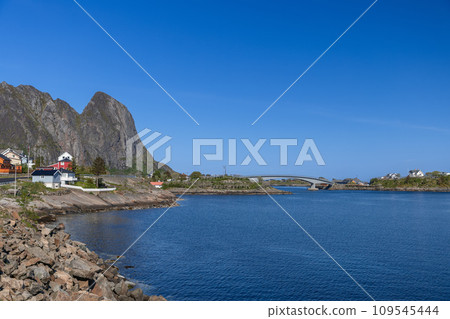 Serene Nordic seascape in Lofoten, Norway with sunlit bridge and rocky shores Serene Nordic seascape in Lofoten, Norway with sunlit bridge and rocky shores 109545444