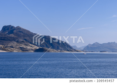 Picturesque North Sea with towering mountain and sailing boat near Lofoten Island, sunny summer day 109545457