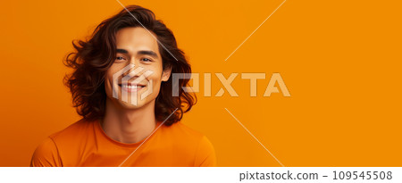 Handsome young male guy smile Asian with long red hair, on yellow orange background, banner, 109545508