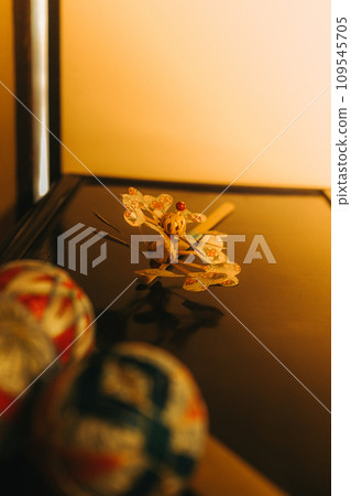 A ball and bamboo windmill above the chest of drawers 109545705