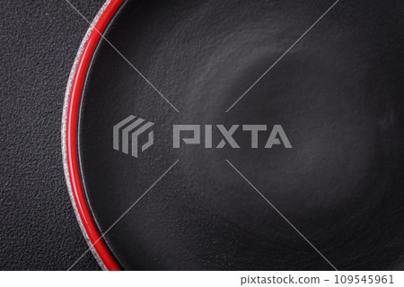 Bumpy empty ceramic plate on a textured concrete background Bumpy empty ceramic plate on a textured concrete background 109545961