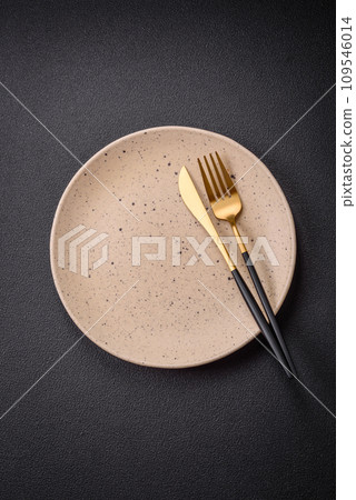 Bumpy empty ceramic plate on a textured concrete background Bumpy empty ceramic plate on a textured concrete background 109546014
