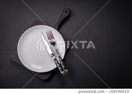 Bumpy empty ceramic plate on a textured concrete background 109546019
