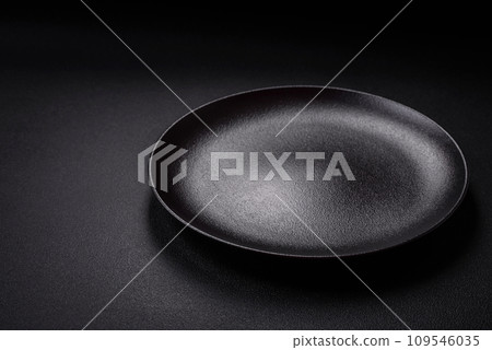 Bumpy empty ceramic plate on a textured concrete background Bumpy empty ceramic plate on a textured concrete background 109546035