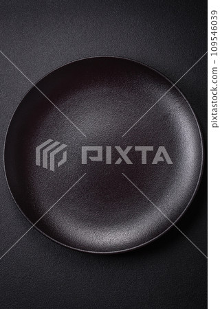 Bumpy empty ceramic plate on a textured concrete background 109546039