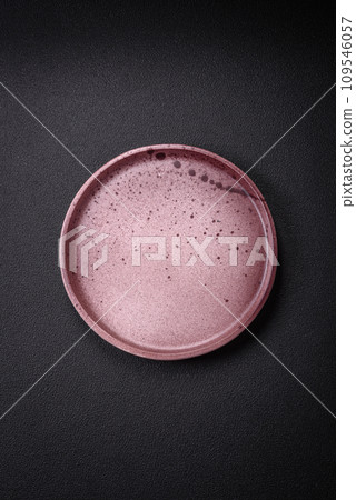 Bumpy empty ceramic plate on a textured concrete background 109546057
