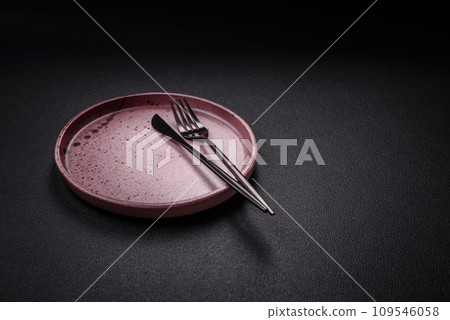 Bumpy empty ceramic plate on a textured concrete background 109546058