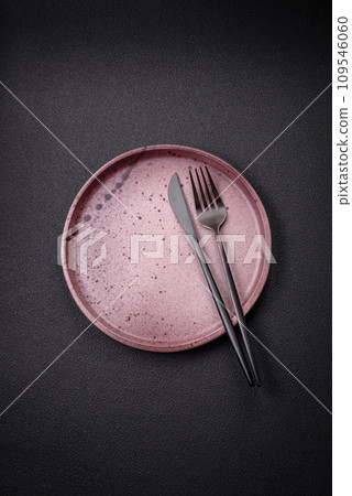 Bumpy empty ceramic plate on a textured concrete background 109546060