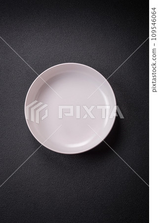 Bumpy empty ceramic plate on a textured concrete background Bumpy empty ceramic plate on a textured concrete background 109546064