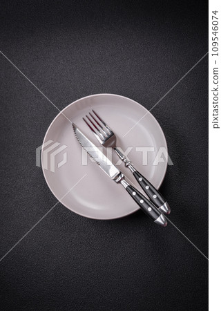 Bumpy empty ceramic plate on a textured concrete background Bumpy empty ceramic plate on a textured concrete background 109546074