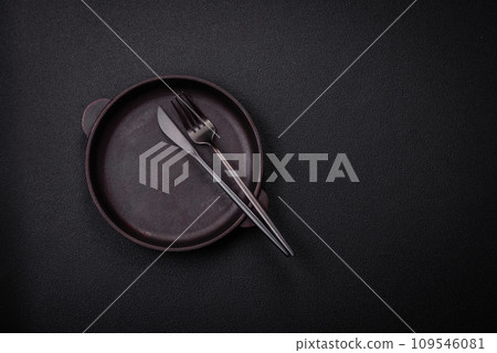 Bumpy empty ceramic plate on a textured concrete background 109546081