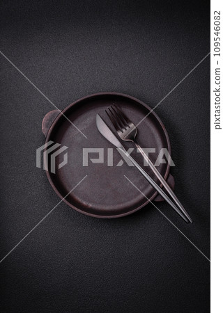 Bumpy empty ceramic plate on a textured concrete background 109546082