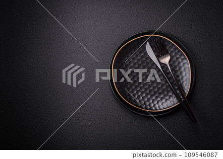 Bumpy empty ceramic plate on a textured concrete background Bumpy empty ceramic plate on a textured concrete background 109546087