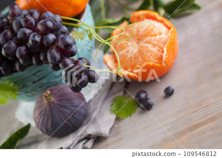 Blue grape, orange tangerine, figs fruit mix, healthy food background 109546812