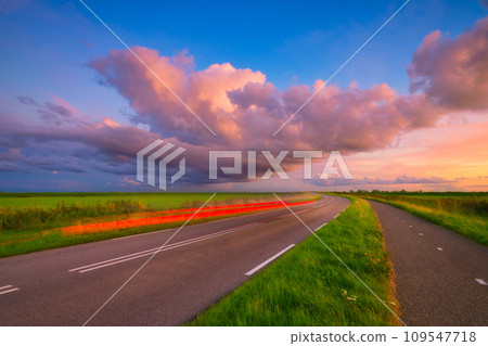 Landscape during sunset with road and clouds. A beautiful asphalt road with sky during sunset. Landscape during sunset with road and clouds. A beautiful asphalt road with sky during sunset. 109547718