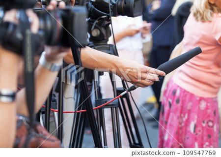TV journalist holding microphone at news conference 109547769
