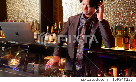 Young male DJ playing music on turntables 109548236