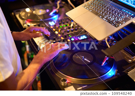 Hands of a DJ playing on turntables 109548240
